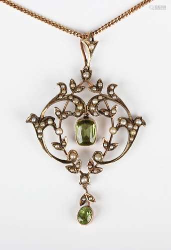 An Edwardian gold, peridot and half-pearl pendant in a scrol...