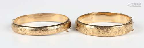 Two 9ct gold oval hinged bangles, each front with engraved d...