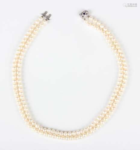 A two row necklace of freshwater cultured pearls on a white ...