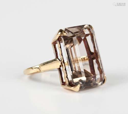 A 9ct gold ring, claw set with a rectangular cut pale smoky ...