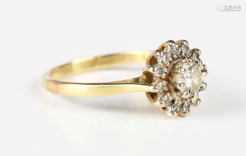 A gold and diamond cluster ring, claw set with the principal...