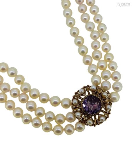 A three row pearl necklace with an amethyst clasp,