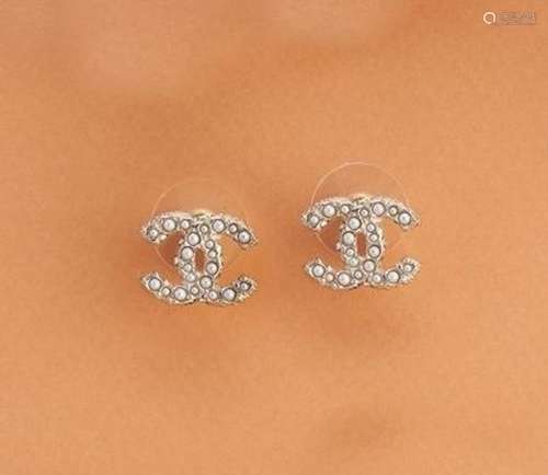 CHANEL<br />
PAIRE DE BOUCLES D'OREILLES en métal doré et pe...