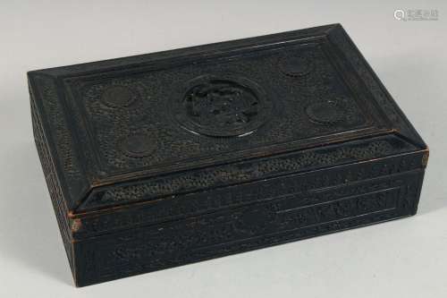 A CHINESE CARVED AND EBONISED WOODEN BOX, the hinged lid car...