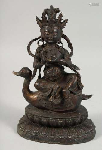 A LARGE BRONZE FIGURE OF A SEATED DEITY, sat upon a bird and...