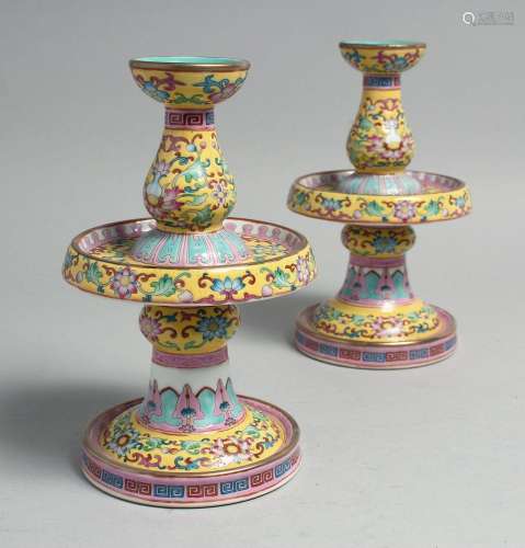 A PAIR OF CHINESE FAMILLE JAUNE PORCELAIN CANDLESTICKS, each...