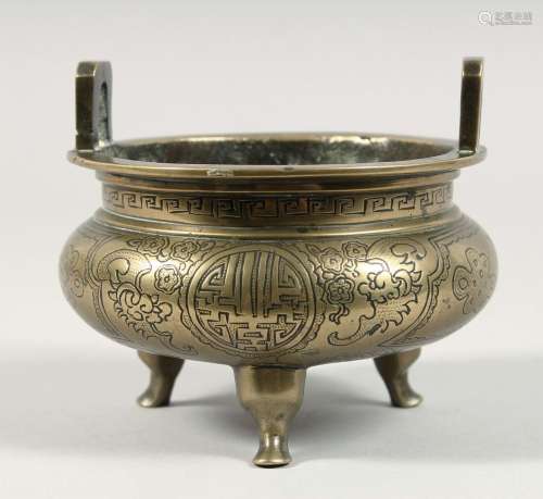 A CHINESE GILT BRONZE TWIN HANDLE TRIPOD CENSER, with engrav...