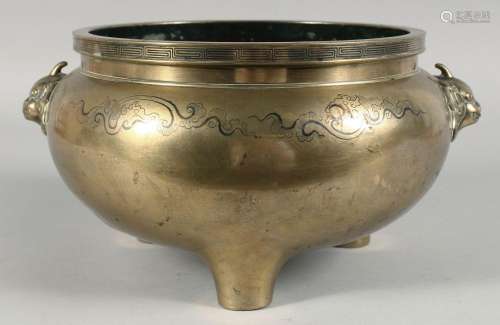A LARGE CHINESE BRASS TWIN HANDLE TRIPOD CENSER, the handles...