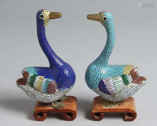 A PAIR OF CHINESE CLOISONNE MODELS OF GEESE on wooden stands...