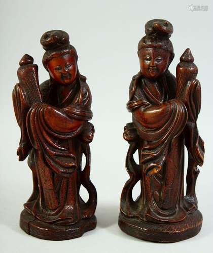 A PAIR OF CHINESE CARVED WOOD FEMALE FIGURES, 22cm and 21cm.