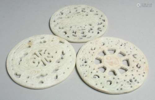 THREE CHINESE CARVED AND PIERCED HARDSTONE PLAQUES, 12cm dia...