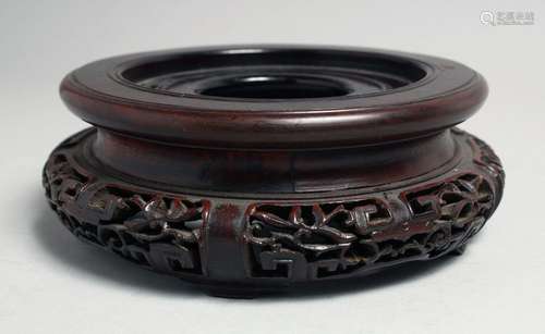 A CHINESE CARVED HARDWOOD CIRCULAR VASE STAND, to fit a base...