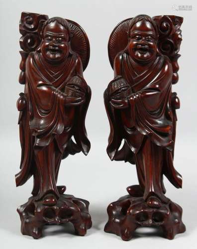 A PAIR OF CHINESE CARVED HARDWOOD FIGURES, raised on pierced...