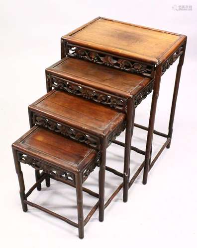 A CHINESE HARDWOOD NEST OF FOUR TABLES, each with carved fri...