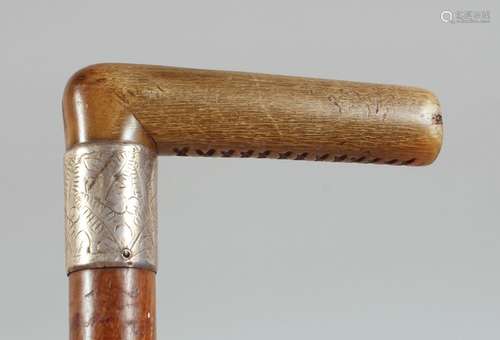 AN ANTIQUE RHINO HORN HANDLE WALKING STICK, with silver band...