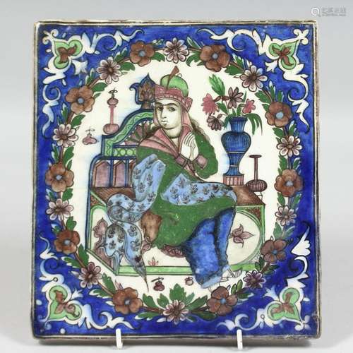 A PERSIAN GLAZED POTTERY TILE, central depicting a seated fi...