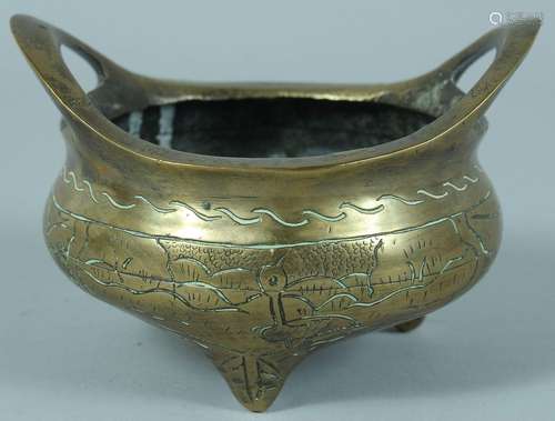 A SMALL CHINESE BRASS TWIN HANDLE TRIPOD CENSER, 13.5cm wide...