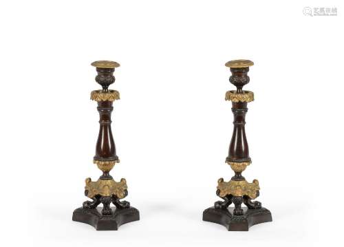 A PAIR OF PATINATED AND GILT METAL CANDLESTICKS IN LOUIS PHI...