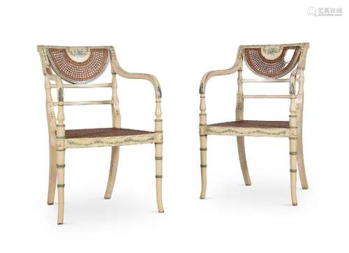 A PAIR OF CREAM PAINTED AND CANED OPEN ARMCHAIRS