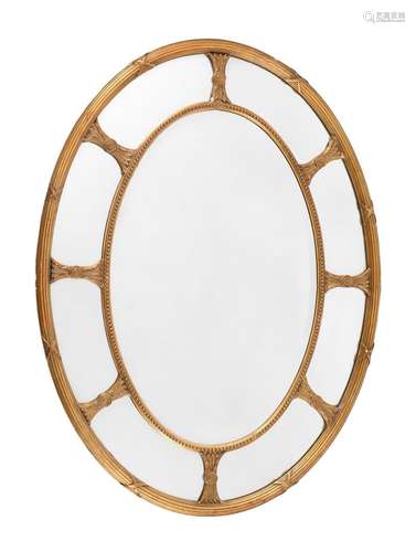 A GILTWOOD AND COMPOSITION OVAL WALL MIRROR IN GEORGE III ST...