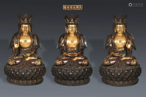 THREE CHINESE PARCEL-GILT-BRONZE FIGURES OF TRIKALA BUDDHAS,...