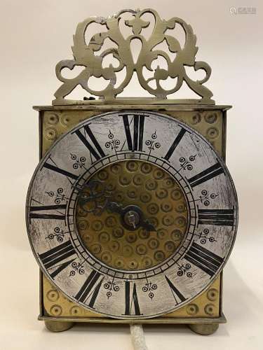 A brass cased lantern single hand clock having a 6" sil...
