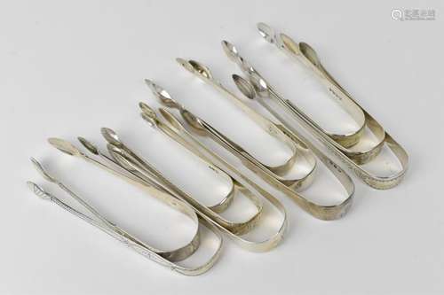 A collection of George III silver sugar tongs, some with bri...