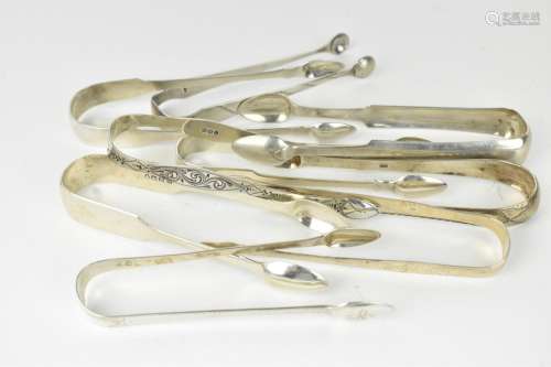 A collection of George III silver sugar tongs, some with bri...