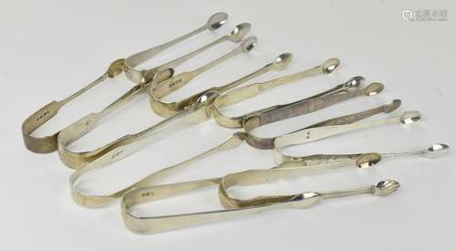 A collection of George III silver sugar tongs, some with bri...