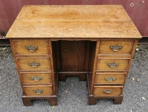 A Georgian oak kneehole desk, the rectangular top above an a...