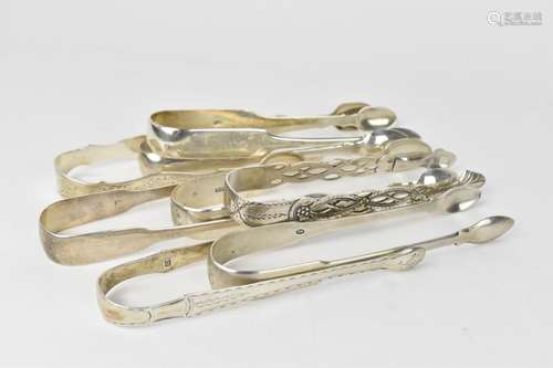 A collection of George III silver sugar tongs, some with sti...