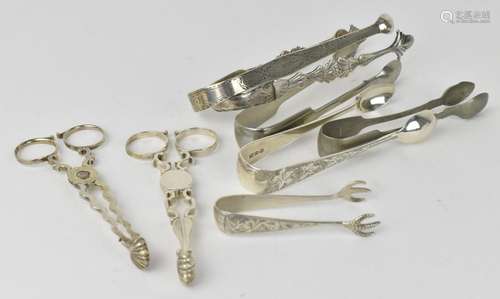 A small collection of mixed silver sugar tongs and scissors,...