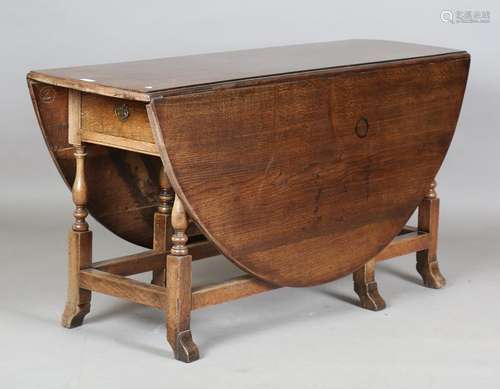 An 18th century oak oval drop-flap dining table