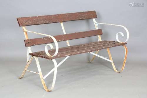 A 20th century wrought iron and wooden slatted garden bench