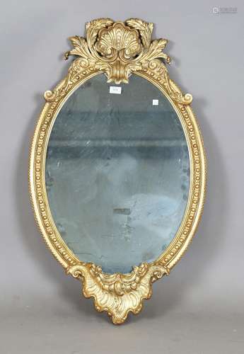 A modern rococo style gilt framed oval wall mirror