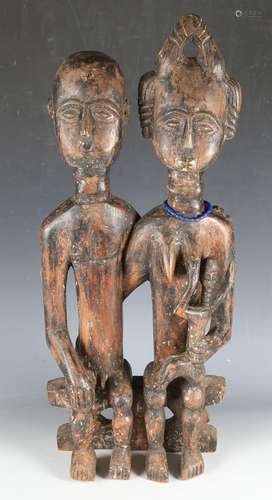 An African carved wooden figure group of a seated couple wit...