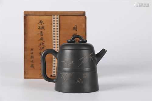 A PURPLE CLAY TEAPOT WITH CARVED BAMBOO DESIGN.