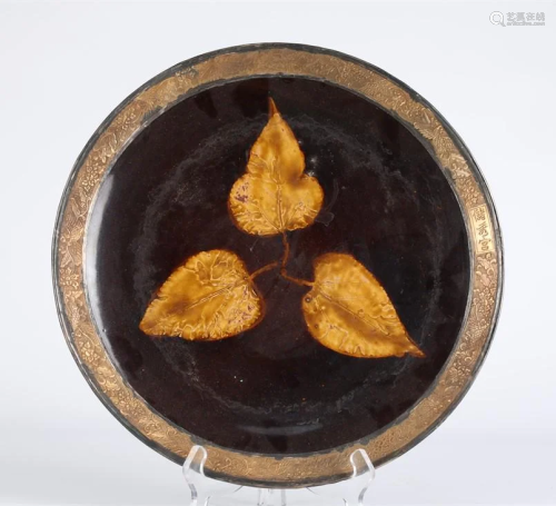 A PORCELAIN PLATE WITH INNER LEAVES DESIGN.