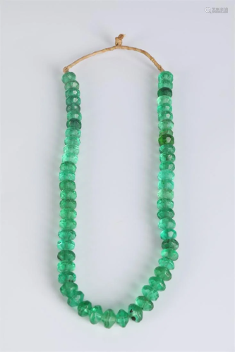 A STRING OF GREEN CRYSTAL BEADS.
