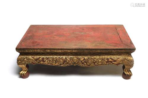 A rectangular gilt wooden low table decorated with a scrolli...