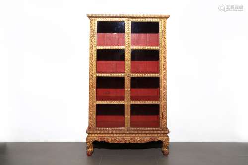 A gilt wooden cabinet carved with flowers blossoming scrolls...