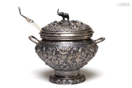 A carved and repousse' silver tureen with ladle decorat...