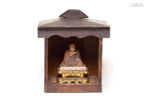 A carved wooden figure of Kukai with cabinet