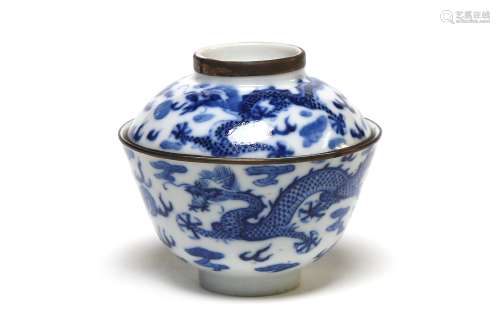 A blue and white covered teacup painted with dragons amid cl...