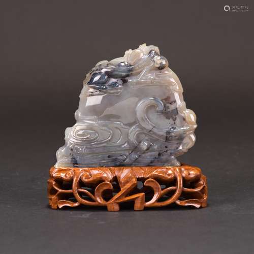 AN AGATE CARVING WITH WOODEN BASE