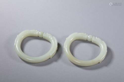 Pair of Qing Hetian jade bangles in form of double-dragon pl...