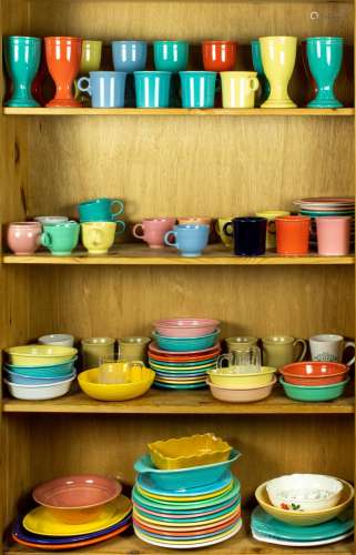 Four shelves of art pottery, mostly Fiestaware