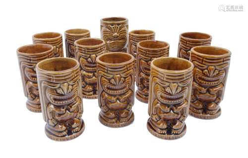 A set of eleven `Tiki Leilani` brown glazed ceramic drinking...