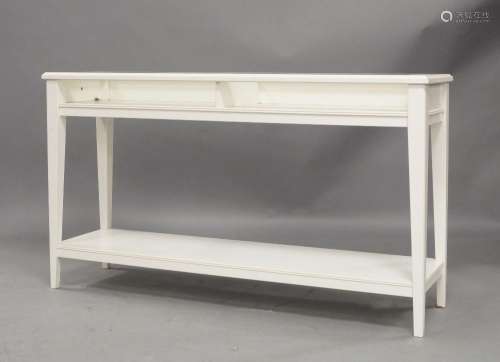 A modern white painted side table, with glass top, raised on...