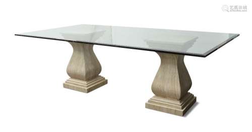 A glass top dining table, raised on variegated stone pedesta...